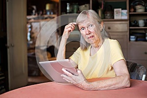 Woman confused with tablet computer