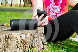 Woman is connecting her smartphone with wireless speaker