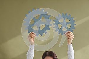 Woman connecting two cogwheels illustrating concept of innovation and integration