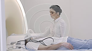 Woman conrtolling panel of magnetic resonance imaging scanner