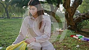 Woman conservationist trash collection engaged in environmental cleanup in park.