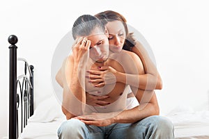 Woman consoling the depressed man in bedroom at home
