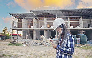 Woman construction engineer hold blueprint wear plaid shirt safety white hard hat at construction site industry labor worker.