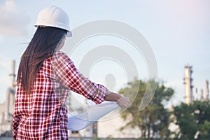 Woman construction engineer hold blueprint wear plaid shirt safety white hard hat at construction site industry labor worker.