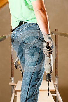 Woman Construction worker with hand drill