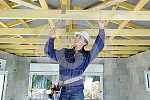 woman construction worker wearing white helmet and tools belt bag