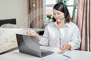 Woman consults by video link with headset with laptop. businesswoman having video conference with business partner on notebook.