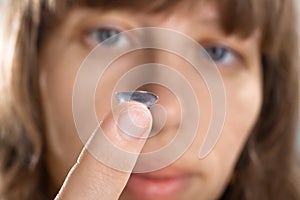 Woman with contact lens on her finger