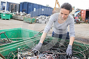 Woman at container cables in salvage yard