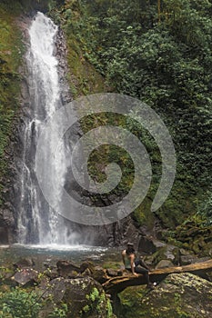 Woman contemplating a waterfall in the middle of the cloud forest