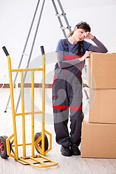 The woman contractor moving boxes in relocation concept