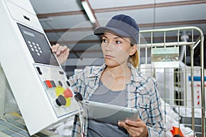 Woman control buttons machine factory operator