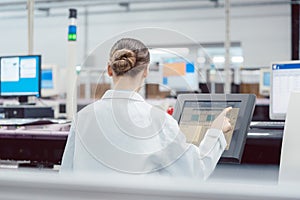 Woman on control compute of assembly line