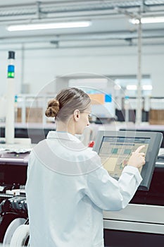 Woman on control compute of assembly line