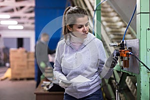 Woman controlling gages of equipments on olive oil factory