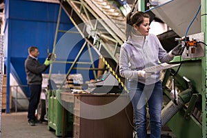 Woman controlling gages of equipments on olive oil factory