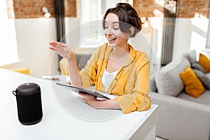 Woman controlling smart home devices with a voice commands