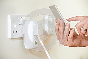 Woman Controlling Smart Plug Using App On Mobile Phone photo