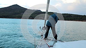 Woman controls the release of an anchor on an anchor chain on yacht in the sea bay