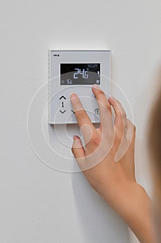 The woman controls the temperature in the house. Air conditioning and heating system in a private house