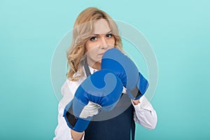 woman in cook apron punching boxing gloves, knockout