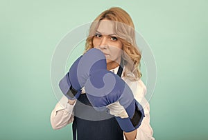 woman in cook apron punching boxing gloves, knockout