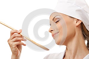 Woman cook eating with spoon, isolated on white