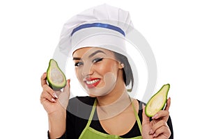 Woman cook holding sliced avocado