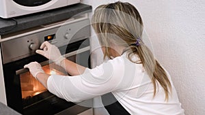 Woman cook sets the right temperature in the oven for baking
