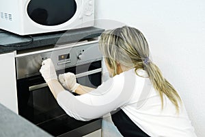 Woman cook sets the right temperature in the oven for baking