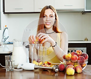 Woman cooking beverages with blender from peaches