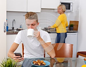 Woman cooking breakfast to her adult son