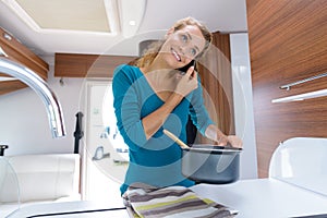 woman cooking in camper while talking on phone