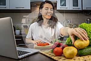 woman cooking checking recipe at laptop