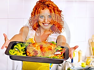 Woman cooking chicken at kitchen.
