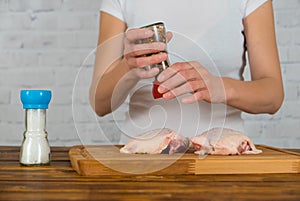 Woman cooking chicken with spicy herbs