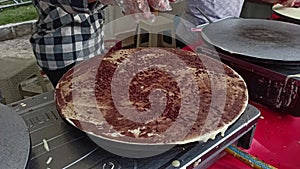 Woman cooking delicious crepe food at the festival