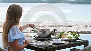 Woman cooking and eating fresh seafood and meat, traditional Japanese dish