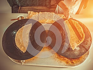 Woman cooking famous traditional Turkish food Gozleme on electrical sac griddle