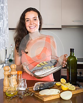 Woman cooking fish at home kitchen