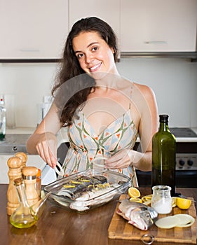 Woman cooking fish at home kitchen