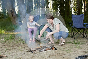 Woman cooking food, people camping in forest, family active in nature, kindle fire, summer season