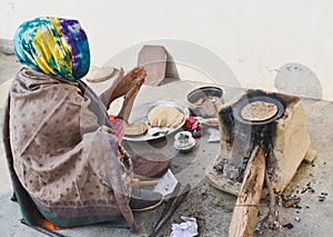 Woman cooking food on wood fire in village of Haryana photo
