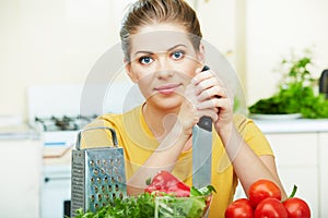 Woman cooking healthy food in the kitchen with knife