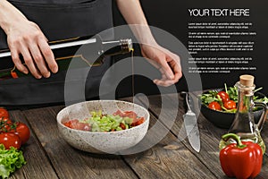 Woman cooking healthy food on wooden table with sample text.Female hands adding olive oil into bowl with vegetable salad