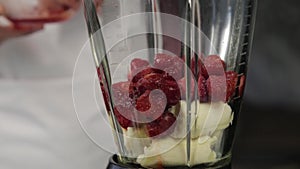 Woman cooking at home, fruit berry cocktail with sesame, close-up of blends ingredients in a mixer. healthy breakfast.
