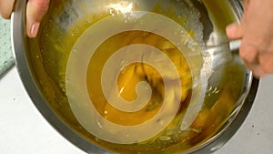 Woman cooking homemade mayonnaise whisking mustard with egg yolks.