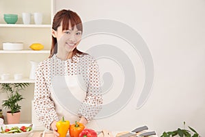 Woman cooking in kitchen with space for copy.