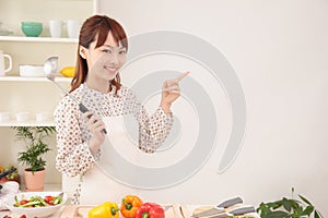 Woman cooking in kitchen with space for copy