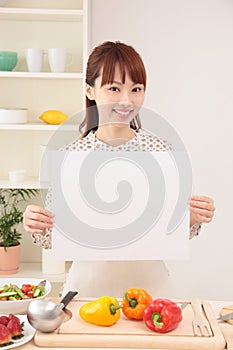 Woman cooking in kitchen with space for copy